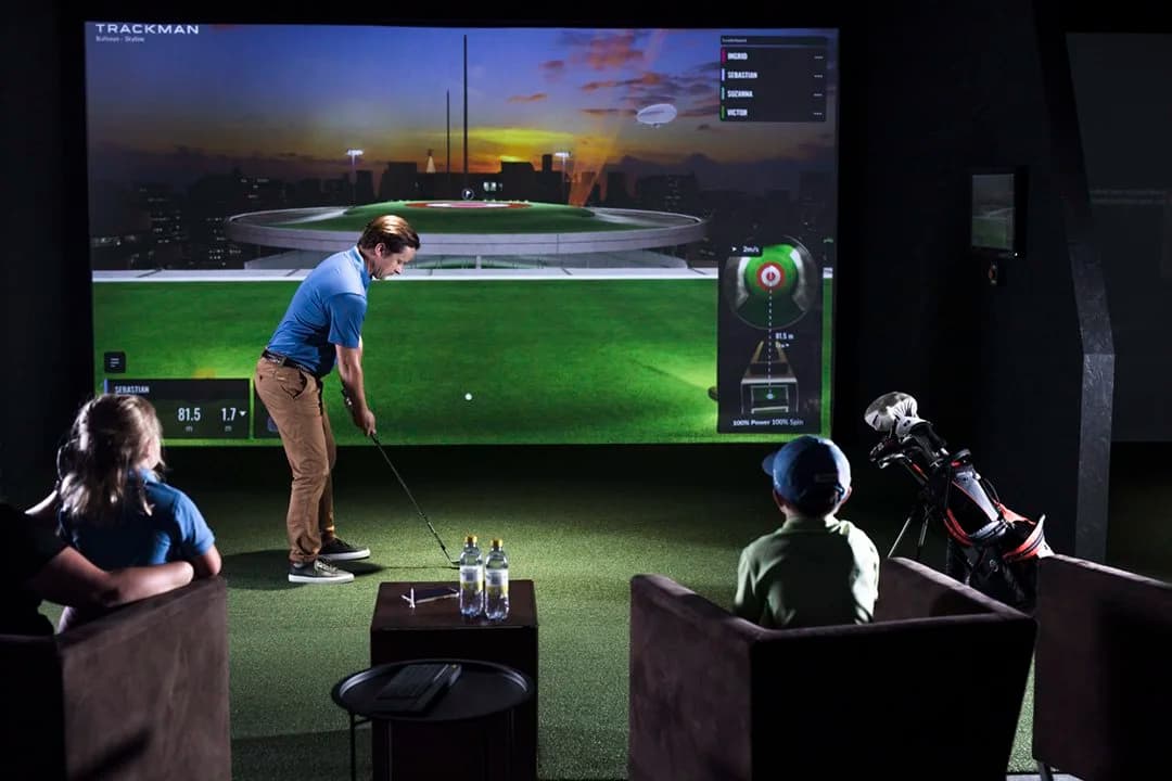 Family enjoying a game of Bullseye together on a TrackMan simulator